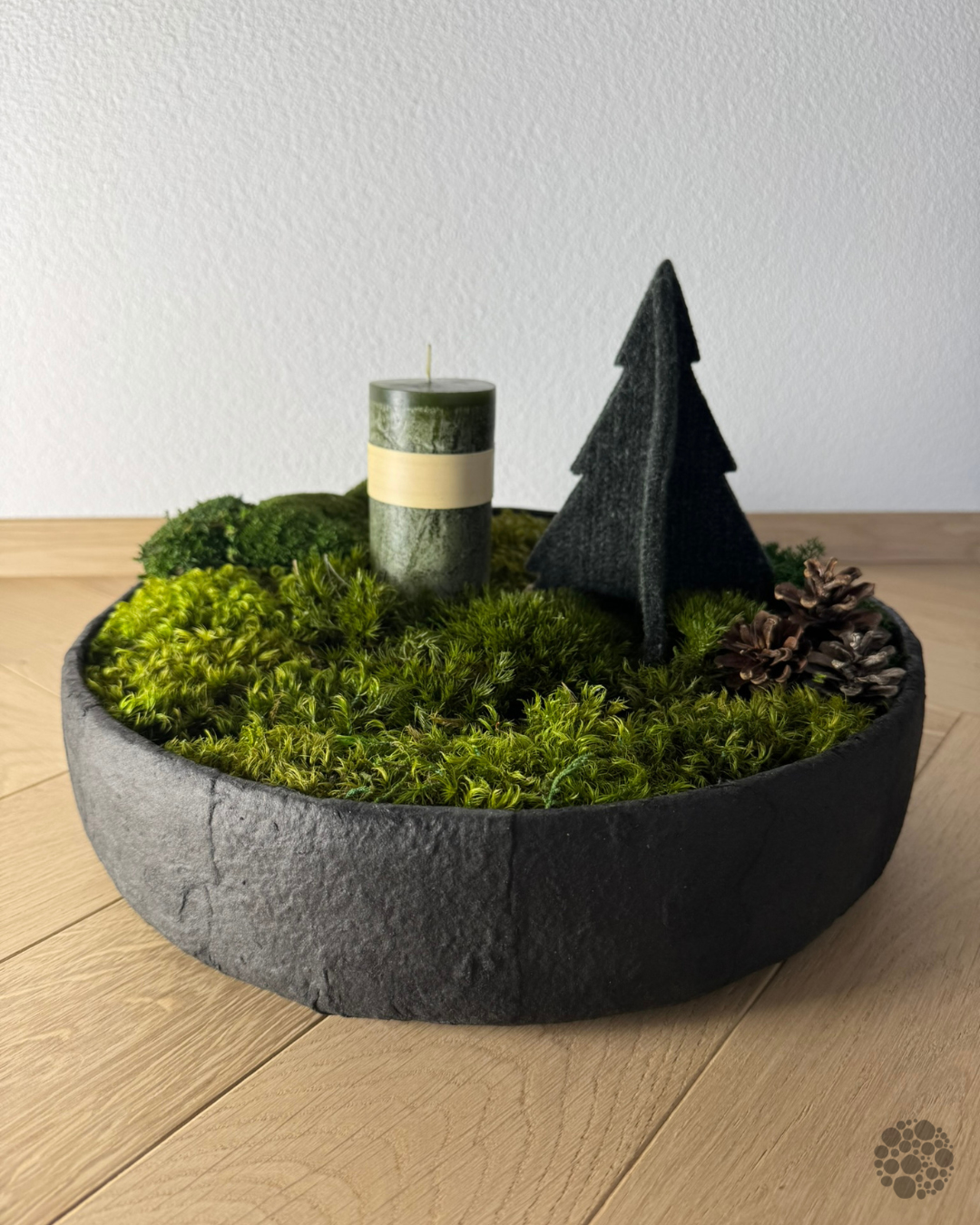 WINTER FOREST: runde anthrazitfarbene Moosschale mit grüner Kerze, Dekobaum und Zapfen